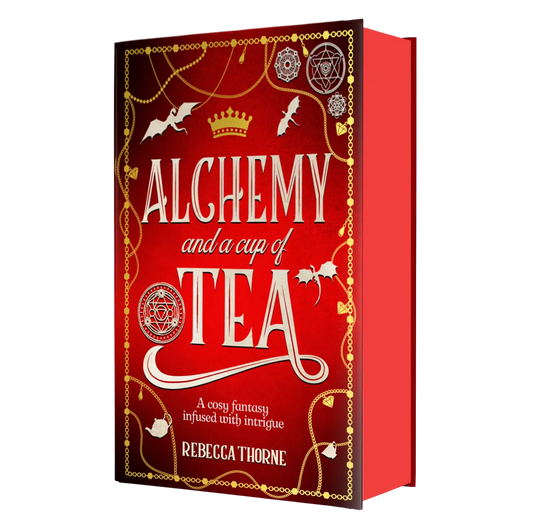 "Alchemy and a Cup of Tea" by Rebecca Thorne is a cozy fantasy novel infused with intrigue, featuring an eye-catching red cover adorned with gold accents, mystical symbols, and flying bats.