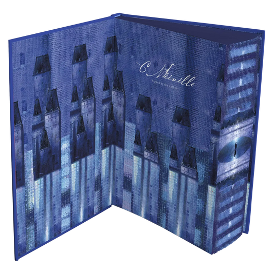 An intricately designed book cover with blue-toned architectural illustrations and a signature by the author.